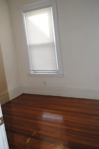 a view of a small space with wooden floor and a window