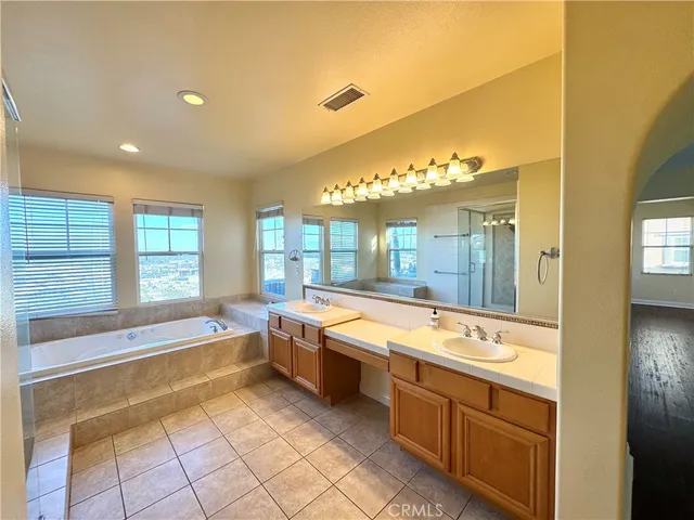 a spacious bathroom with a large tub and sink