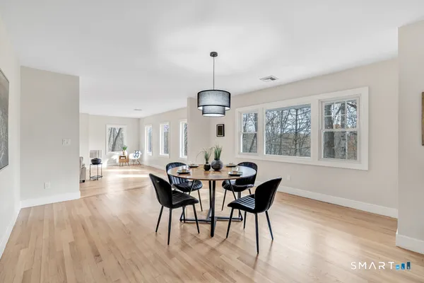 a dining room with furniture a chandelier and wooden floor