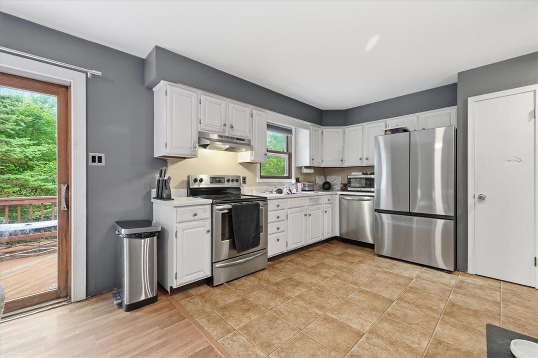 520 Highland Hill Road Jim Thorpe, PA 18235 - Photo 12 of 83 A well-equipped kitchen features crisp white cabinetry and modern stainless steel appliances, creating a functional cooking space.