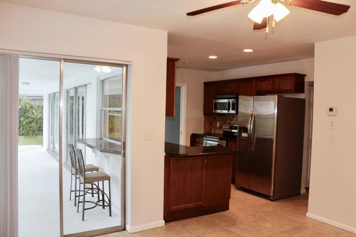 9 Burning Tree Lane Boca Raton, FL 33431 - Photo 12 of 26 a kitchen with kitchen island a counter top space and a view of living room