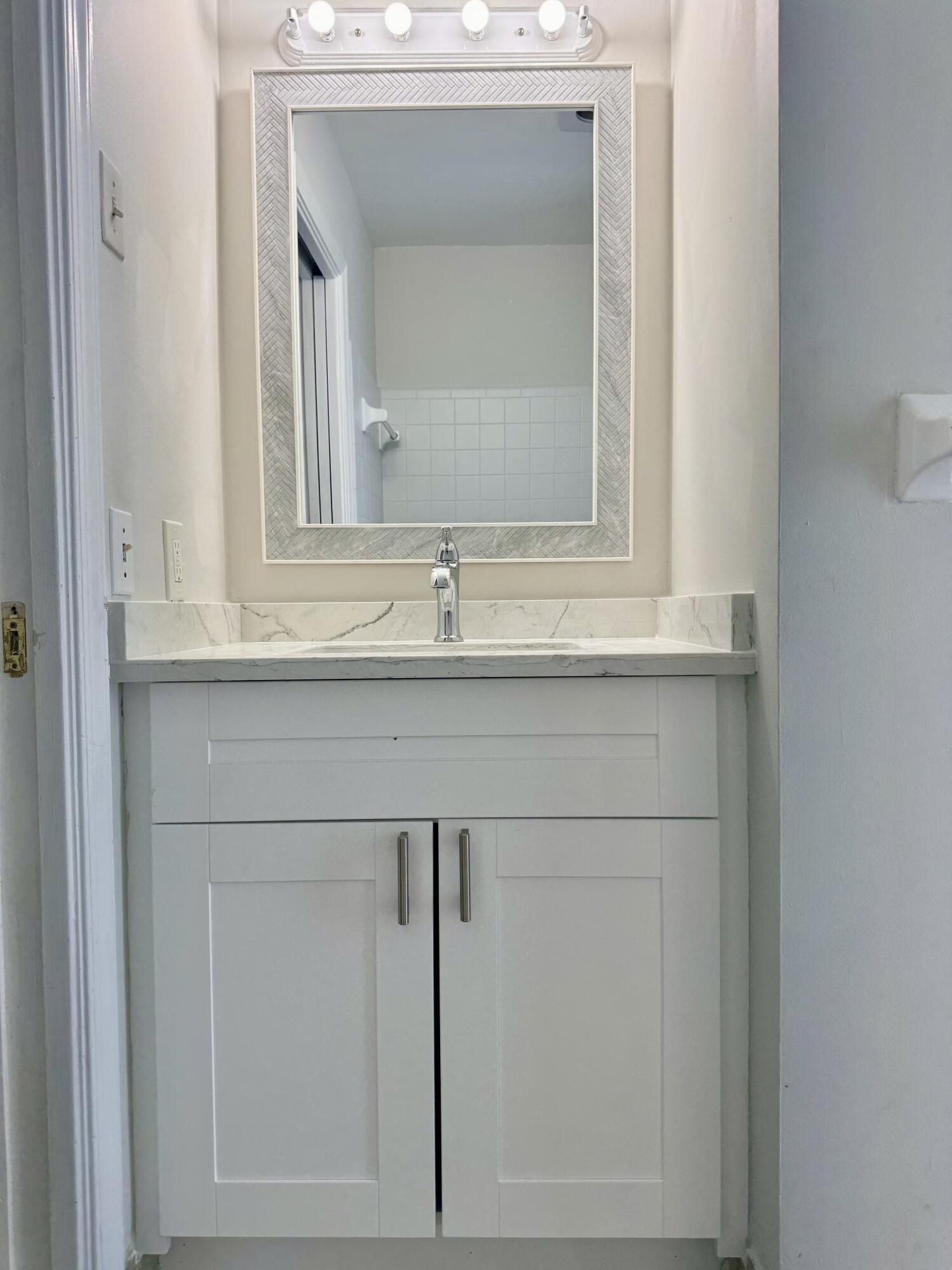 9 Burning Tree Lane Boca Raton, FL 33431 - Photo 24 of 26 a sink with a mirror
