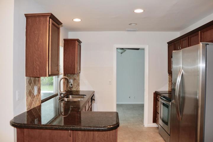 9 Burning Tree Lane Boca Raton, FL 33431 - Photo 9 of 26 a kitchen with kitchen island a counter top space a sink and stainless steel appliances