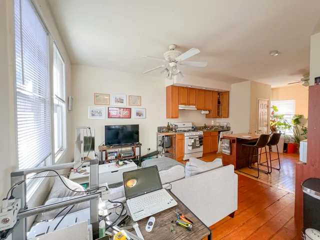 a kitchen with stainless steel appliances granite countertop a stove top oven a sink dishwasher and white cabinets with wooden floor