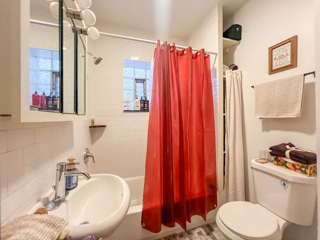 a bathroom with a sink toilet and shower curtain