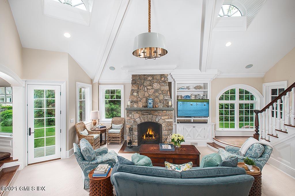 27 Leeward Lane Riverside, CT 06878 - Photo 13 of 38 a living room with furniture a fireplace and a floor to ceiling window