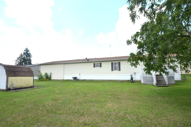a view of a house with a yard and a large tree