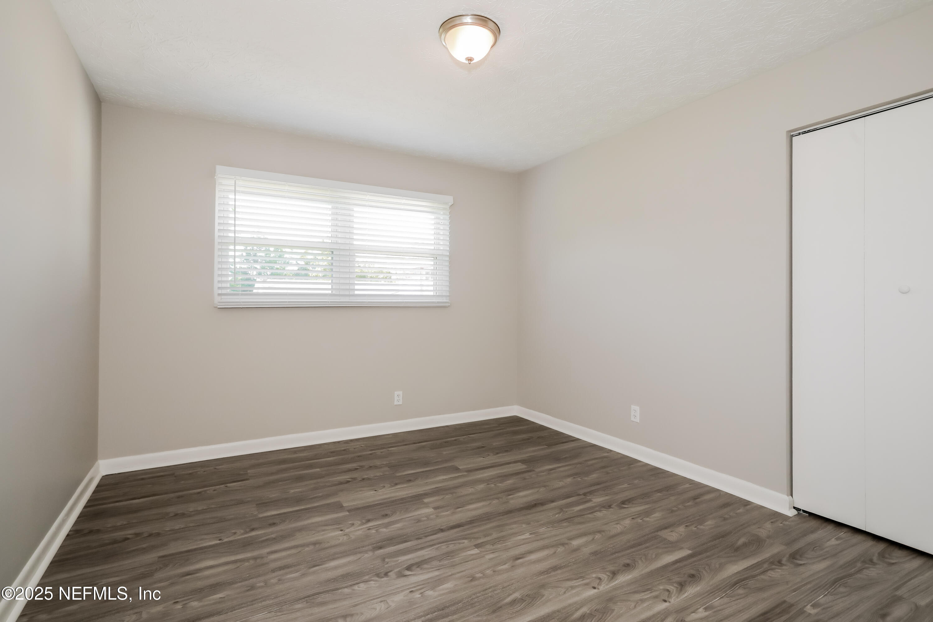 1055 Grove Park Drive Orange Park, FL 32073 - Photo 12 of 15 an empty room with wooden floor and windows