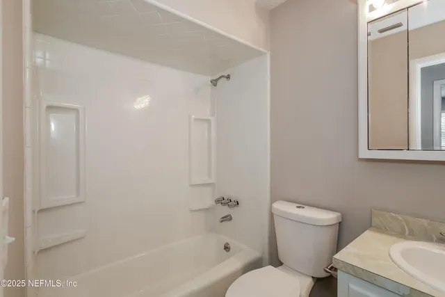 a white toilet sitting next to a bath tub