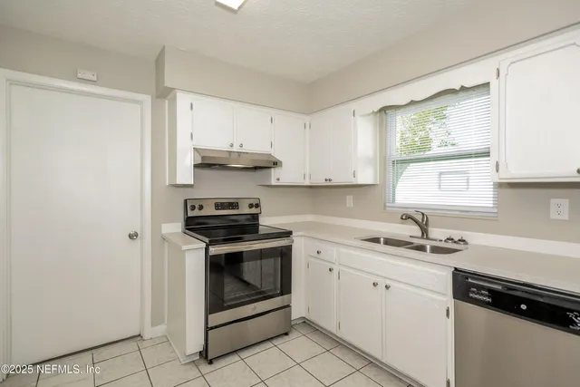 a kitchen with stainless steel appliances granite countertop a sink stove and window
