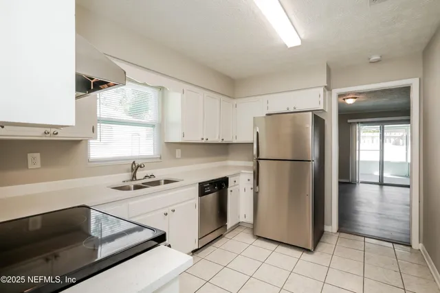 a kitchen with stainless steel appliances a refrigerator sink and microwave