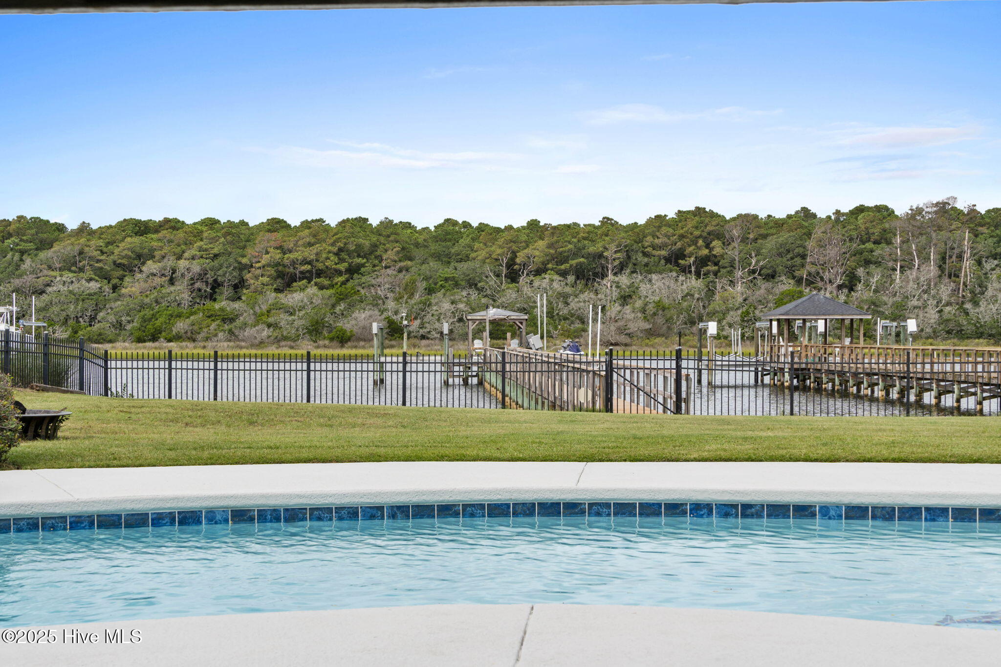 57 Craven Street Ocean Isle Beach, NC 28469 - Photo 55 of 85 Exceptional ICW-front home featuring 5 bedrooms, 5.5 baths, breathtaking water views, private dock with boat lift, and a resort-style outdoor space with pool, porches, and deck.