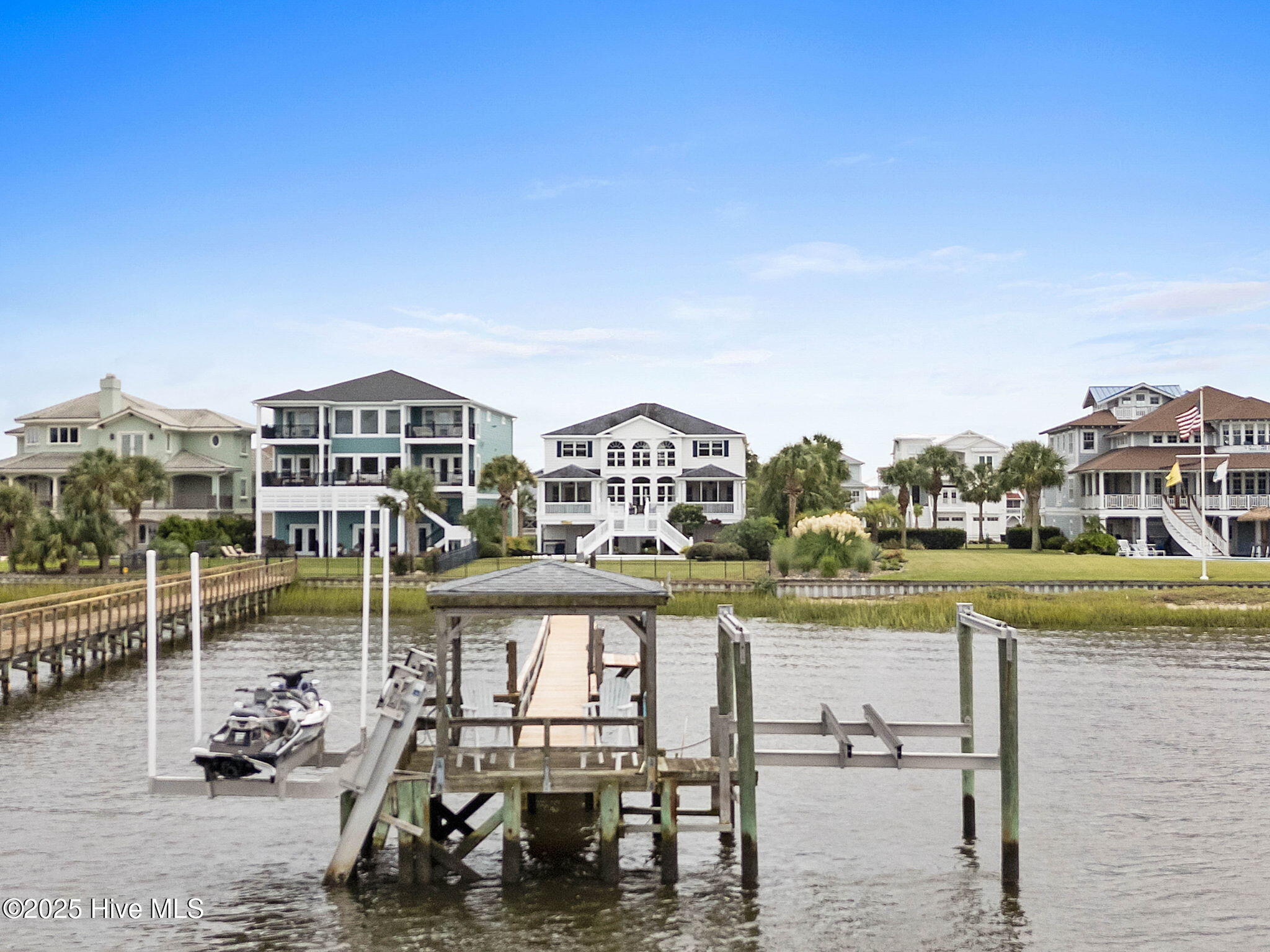 57 Craven Street Ocean Isle Beach, NC 28469 - Photo 60 of 85 Exceptional ICW-front home featuring 5 bedrooms, 5.5 baths, breathtaking water views, private dock with boat lift, and a resort-style outdoor space with pool, porches, and deck.