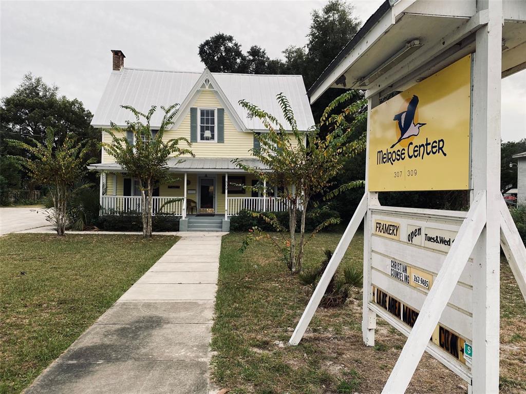 404 Grove Street Melrose, FL 32666 - Photo 26 of 50 a view of a white house with a yard plants and large tree