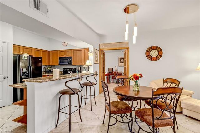 a view of a dining room with furniture and kitchen view