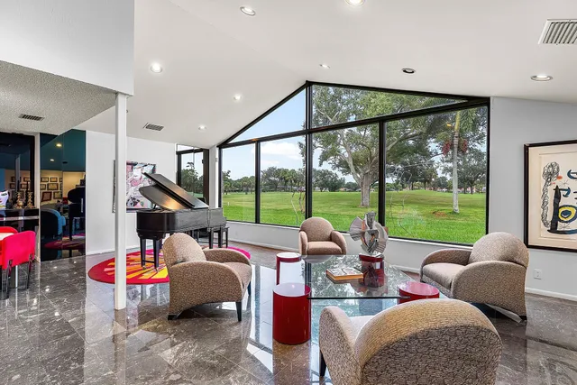 a living room with furniture and a floor to ceiling window