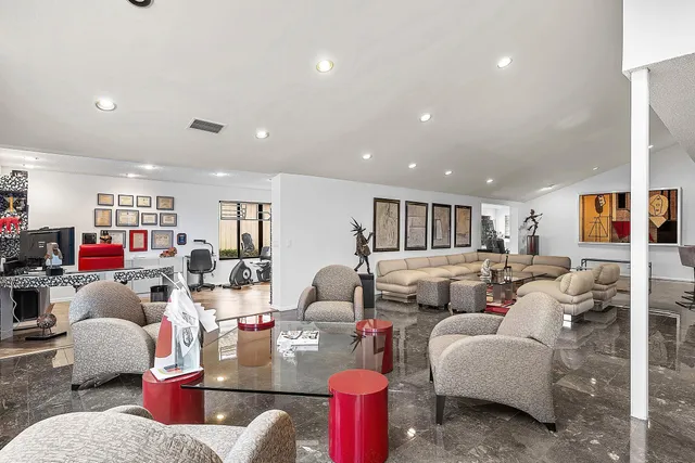 a living room with furniture large window and chairs