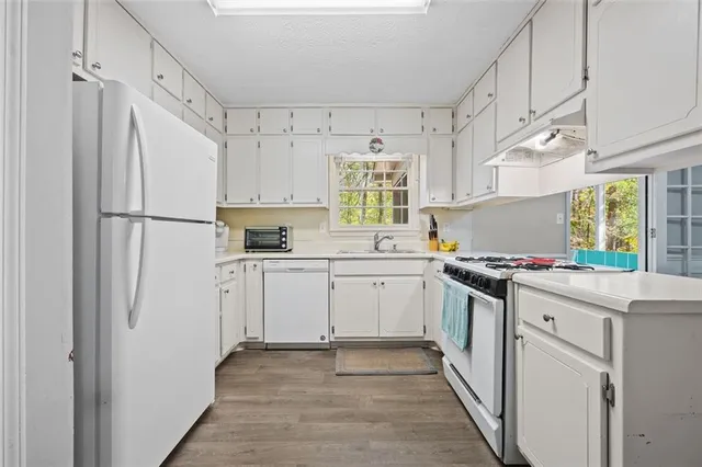 a kitchen with white cabinets and white appliances