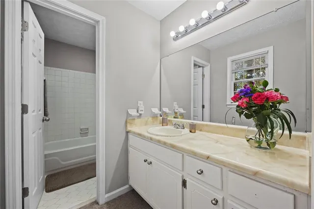 a bathroom with a granite countertop sink a large mirror and a shower