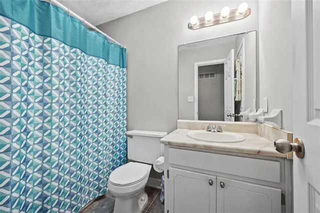 a bathroom with a sink toilet and a mirror