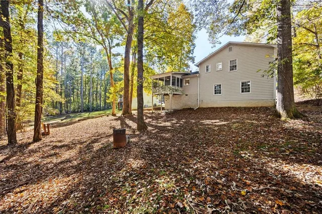 a view of a house with backyard and trees