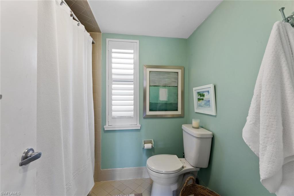263 Candycane Lane, Unit 7 Naples, FL 34112 - Photo 24 of 50 a white toilet sitting next to a bathroom sink and tub