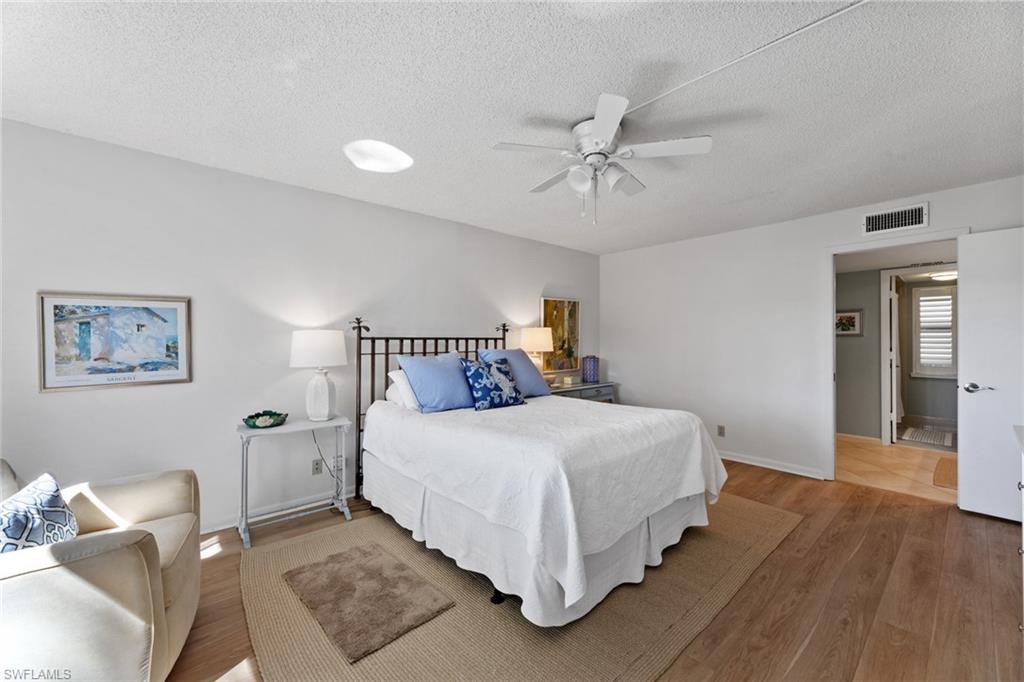 263 Candycane Lane, Unit 7 Naples, FL 34112 - Photo 25 of 50 a bedroom with a bed and wooden floor