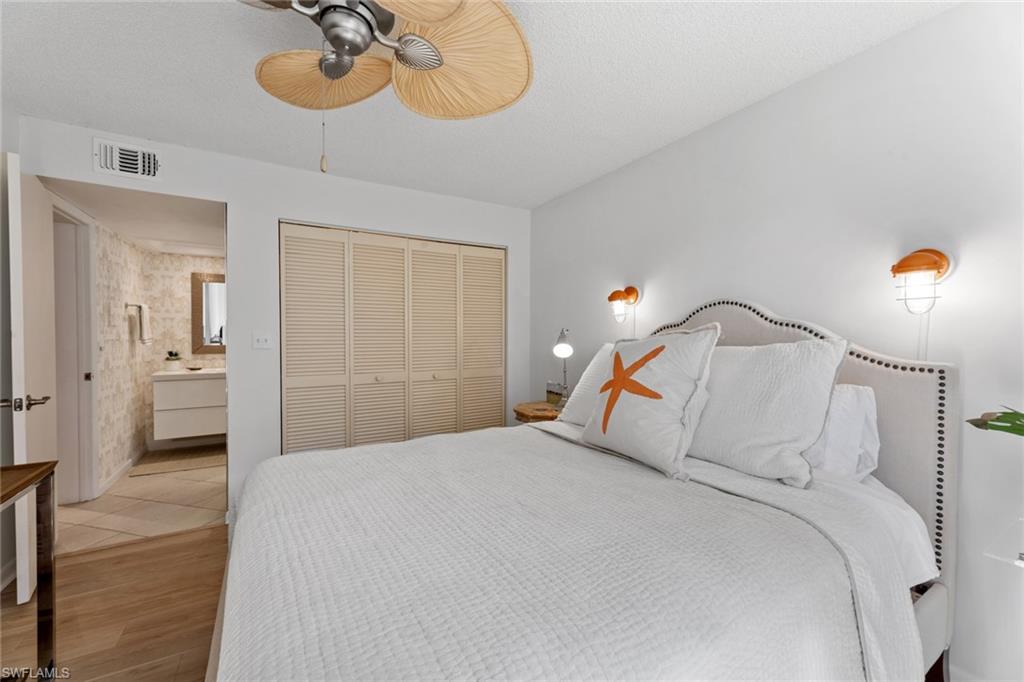 263 Candycane Lane, Unit 7 Naples, FL 34112 - Photo 29 of 50 a bedroom with a bed and a chandelier