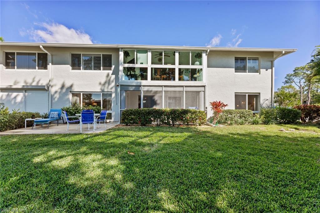 263 Candycane Lane, Unit 7 Naples, FL 34112 - Photo 7 of 50 a front view of house with yard and outdoor seating