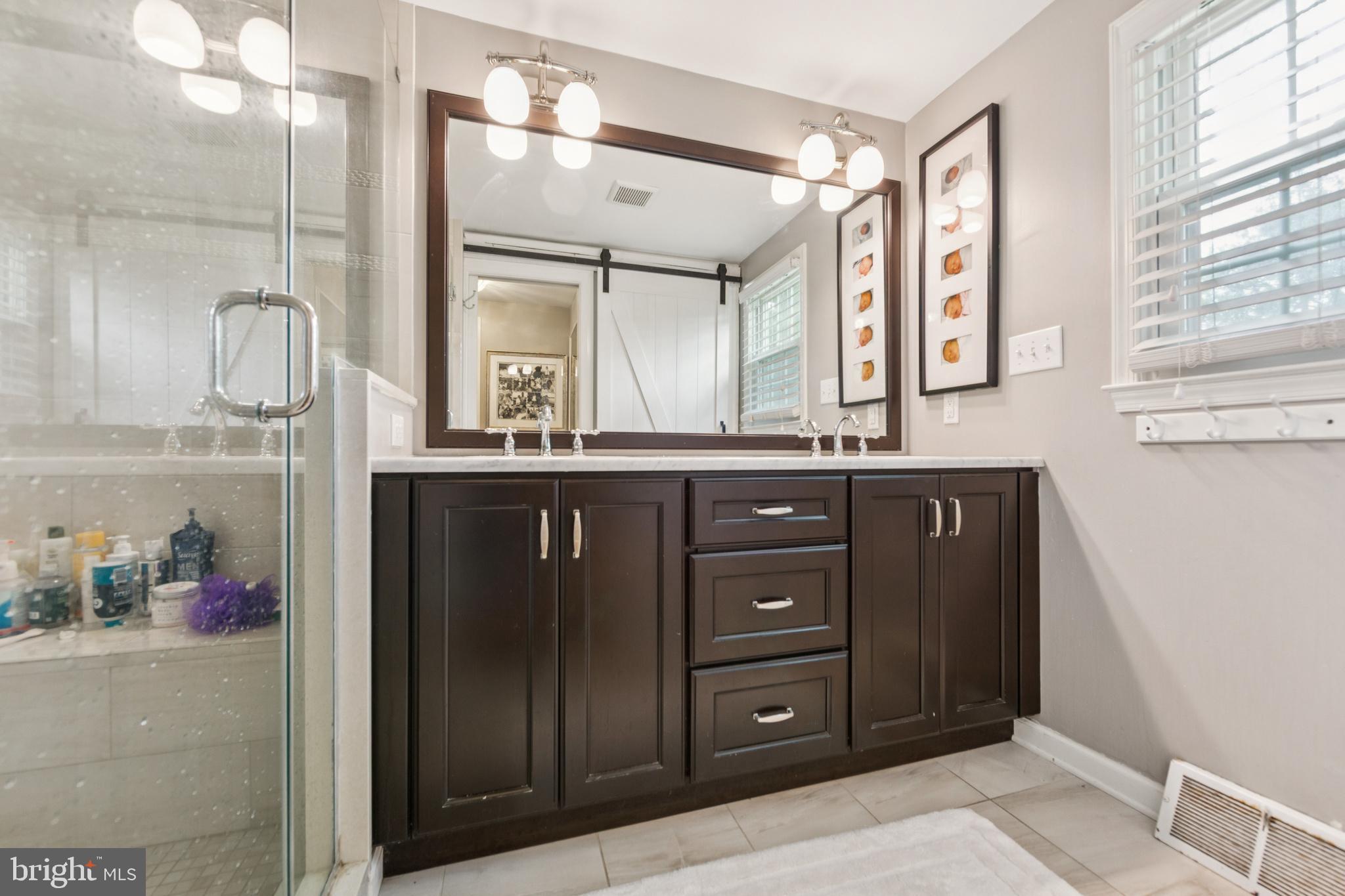 15 Oakford Road Wayne, PA 19087 - Photo 26 of 54 a bathroom with a granite countertop sink a mirror and a shower