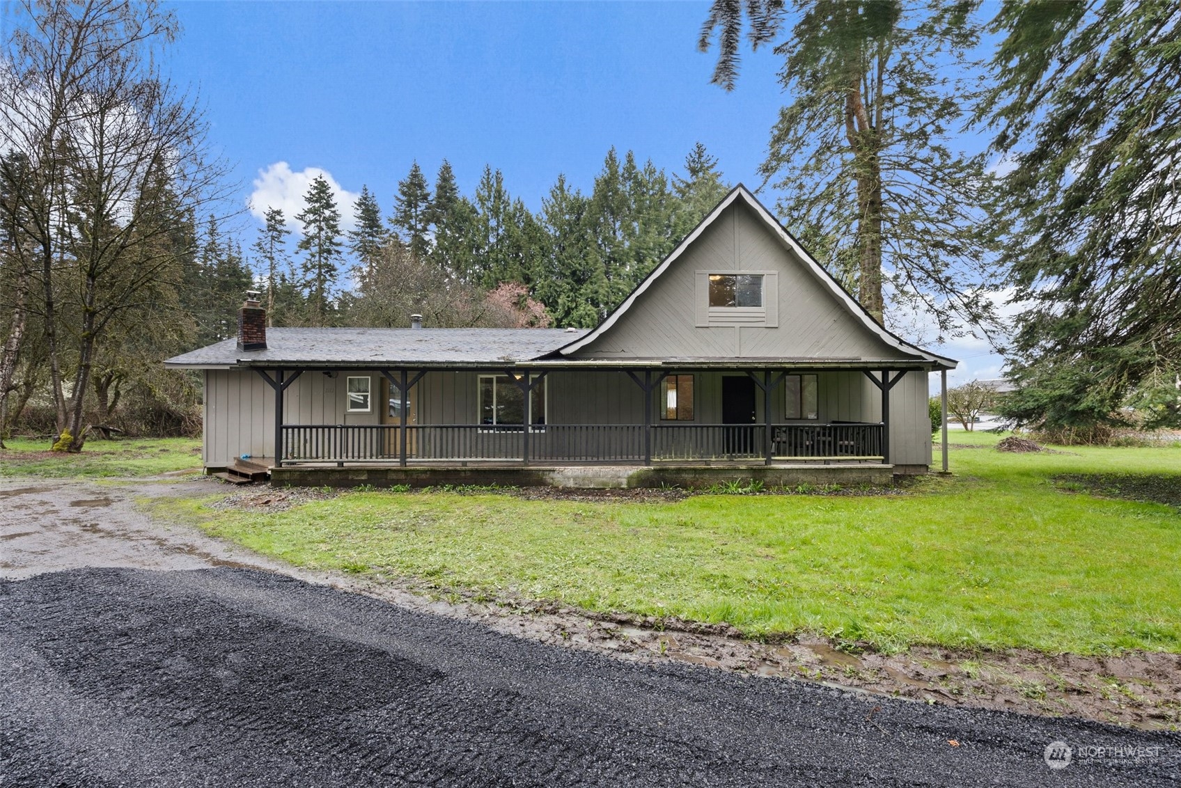 a front view of a house with yard plants and large trees