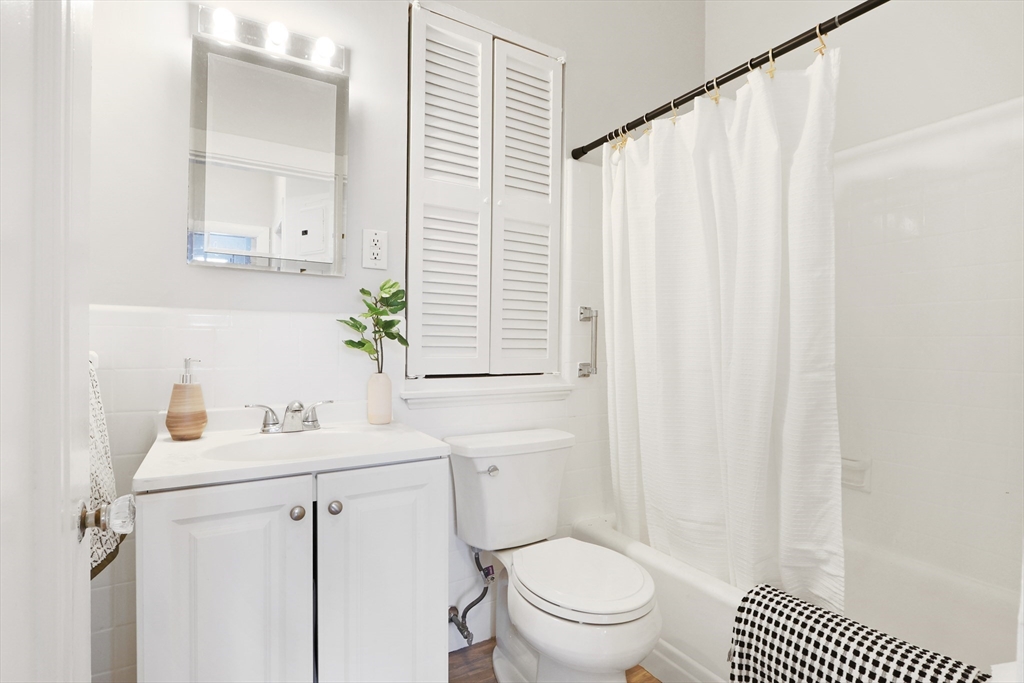 520 Beacon Street, Unit 2F Boston, MA 02215 - Photo 9 of 19 a bathroom with a sink a toilet and shower curtain
