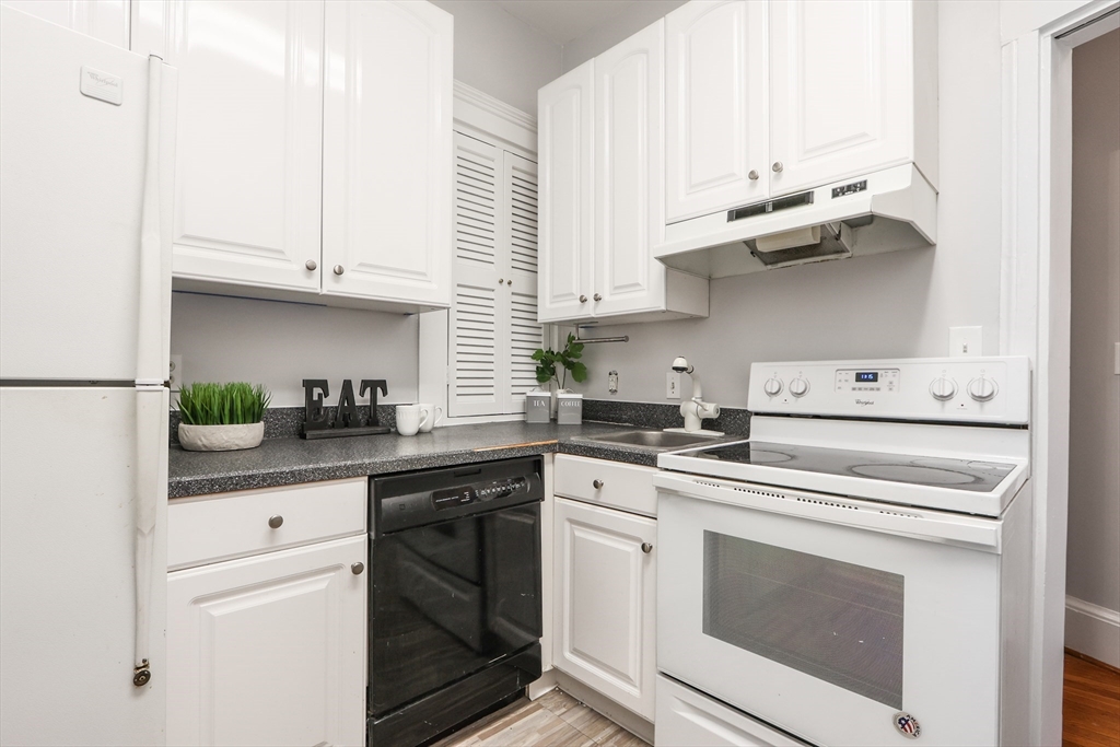 520 Beacon Street, Unit 2F Boston, MA 02215 - Photo 10 of 19 a kitchen with stainless steel appliances white cabinets and white appliances