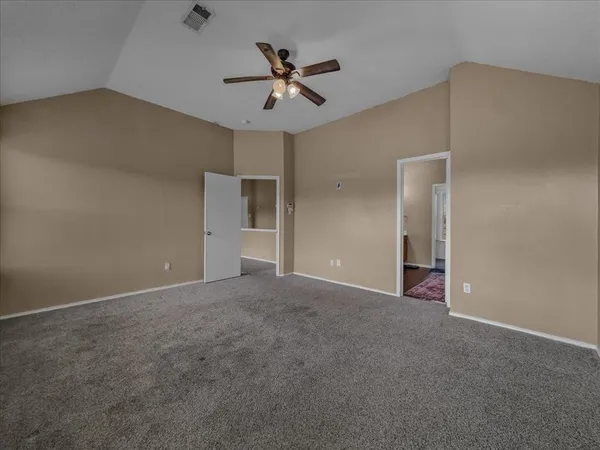 an empty room with closet and ceiling fan