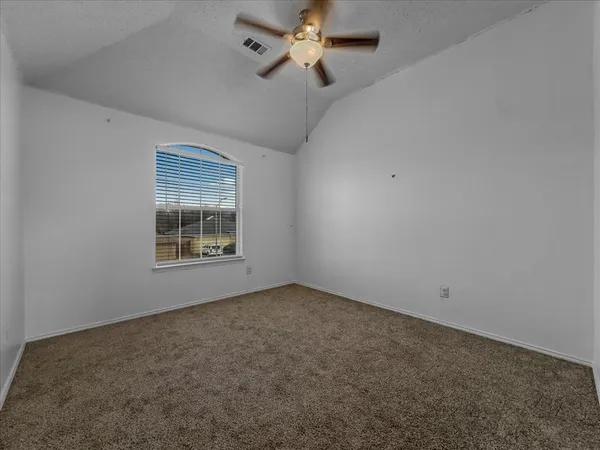 an empty room with a window and ceiling fan
