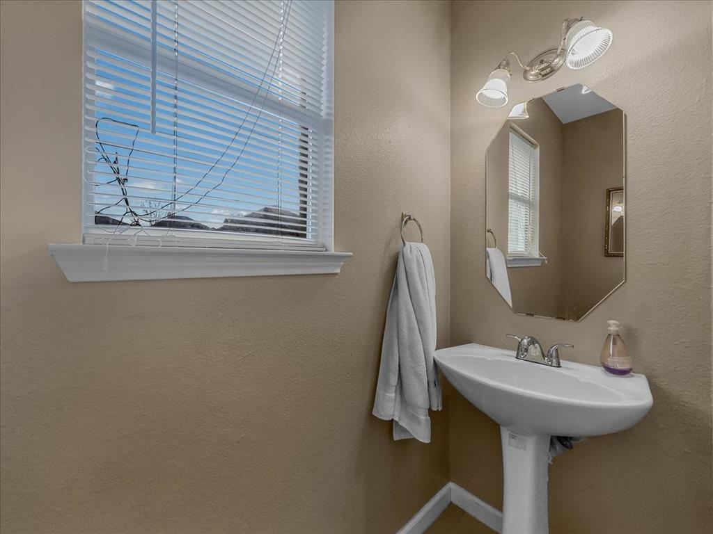 1119 Gaines Mills Road Grand Prairie, TX 75052 - Photo 24 of 29 a bathroom with a sink and a mirror