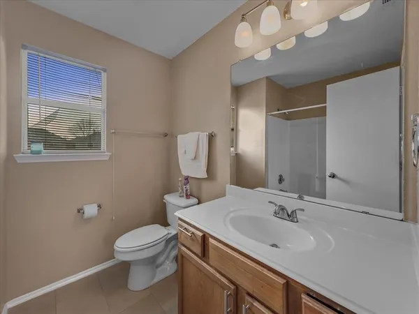 a bathroom with a sink vanity mirror and toilet