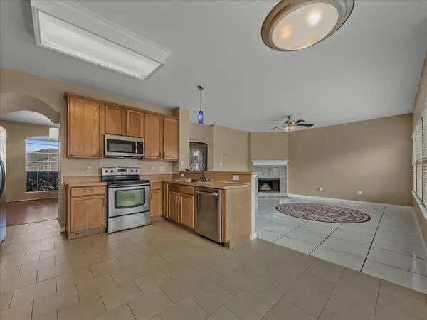 a large kitchen with cabinets wooden floor and stainless steel appliances