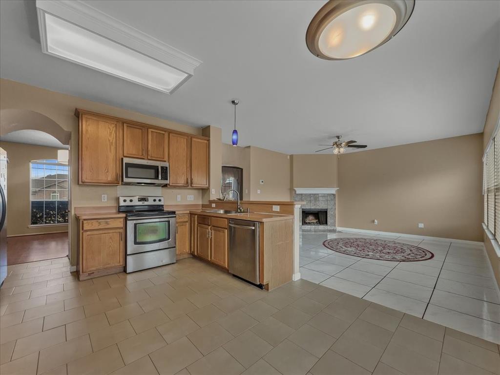 1119 Gaines Mills Road Grand Prairie, TX 75052 - Photo 28 of 29 a large kitchen with cabinets wooden floor and stainless steel appliances