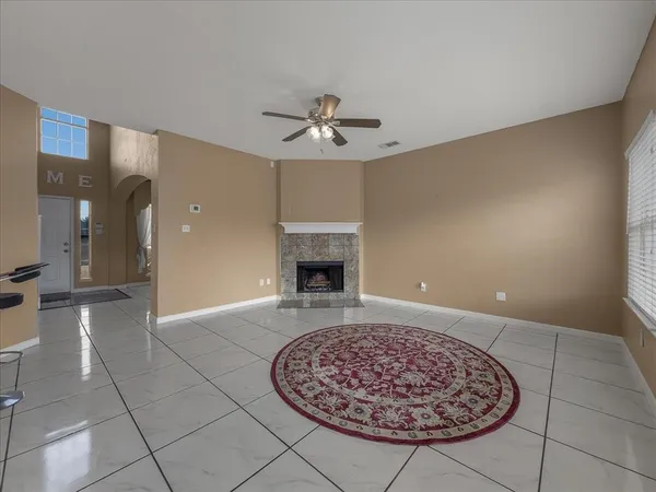 a view of a room with a fireplace and chandelier fan