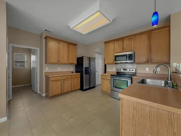 a kitchen with stainless steel appliances a refrigerator sink and microwave