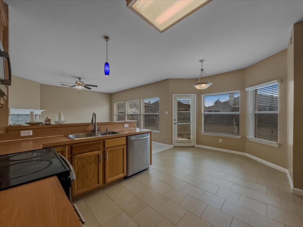 1119 Gaines Mills Road Grand Prairie, TX 75052 - Photo 8 of 29 a kitchen with stainless steel appliances granite countertop a sink and cabinets