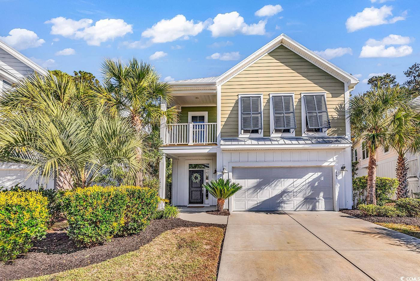 View of front of property with a balcony, a garage, board and batten siding, and driveway