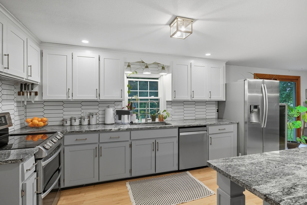 551 West Street Amherst, MA 01002 - Photo 11 of 39 a kitchen with stainless steel appliances granite countertop a sink stove and refrigerator