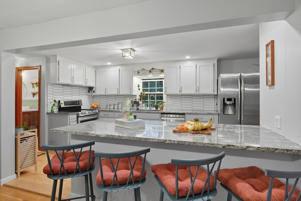 551 West Street Amherst, MA 01002 - Photo 14 of 39 a kitchen with stainless steel appliances granite countertop a refrigerator a sink a stove a dining table and chairs