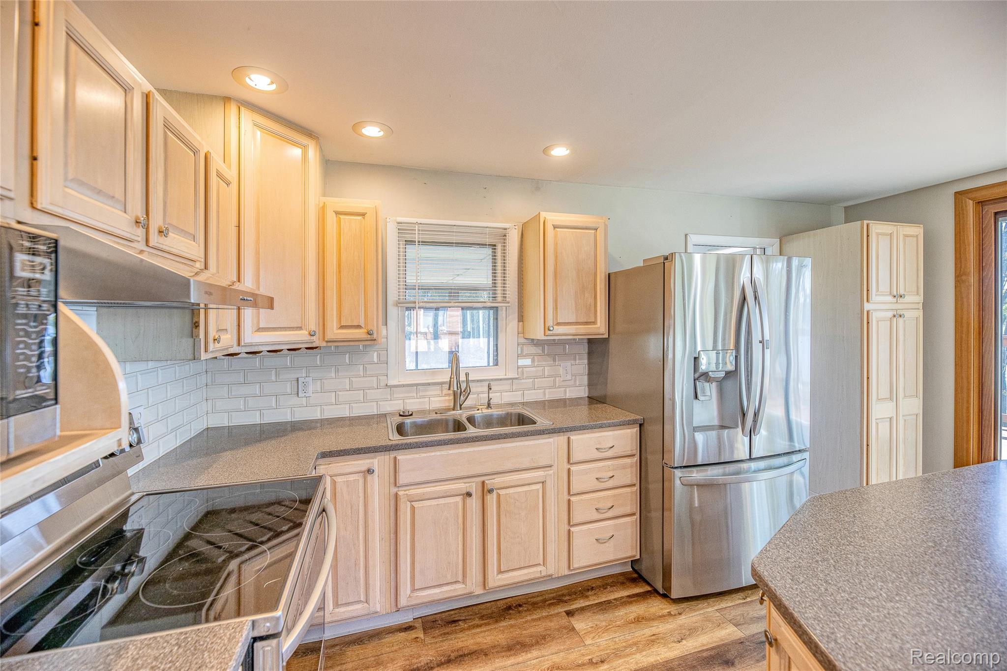 2855 Farmers Creek Road Metamora, MI 48455 - Photo 12 of 51 Kitchen featuring light wood cabinetry, a stainless steel refrigerator, and a built-in microwave