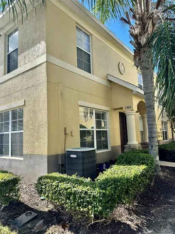 a view of a house with a yard and potted plants
