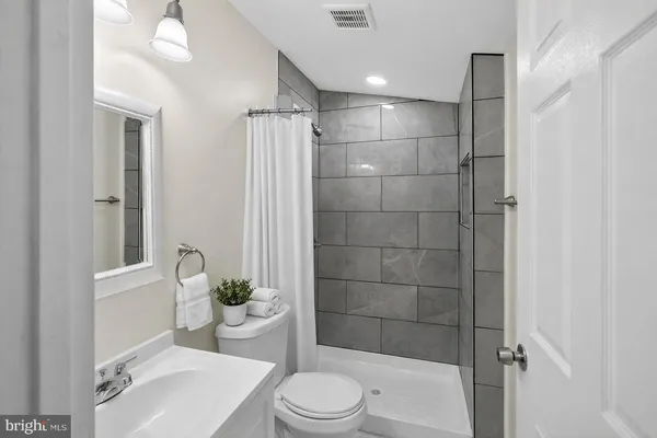 a bathroom with a sink a toilet and shower