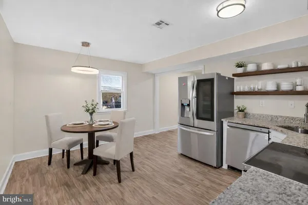 a kitchen with stainless steel appliances wooden floor and dining table