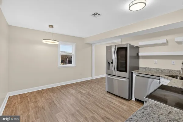 a view of a kitchen with wooden floor and electronic appliances